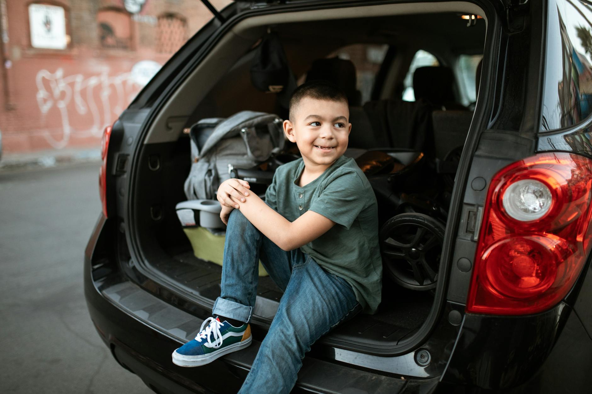 a boy sitting in a car looking over his shoulder