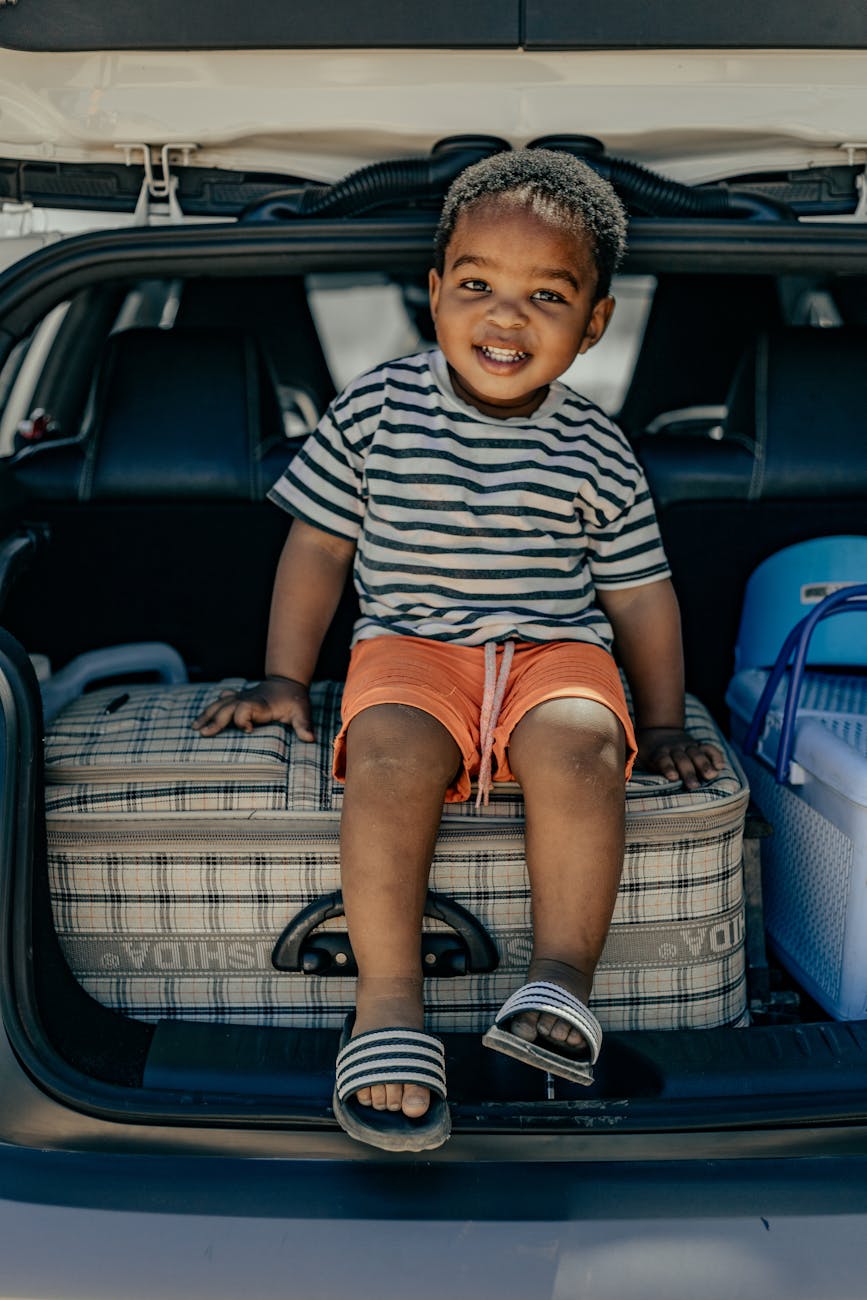 a boy sitting on a suitcase