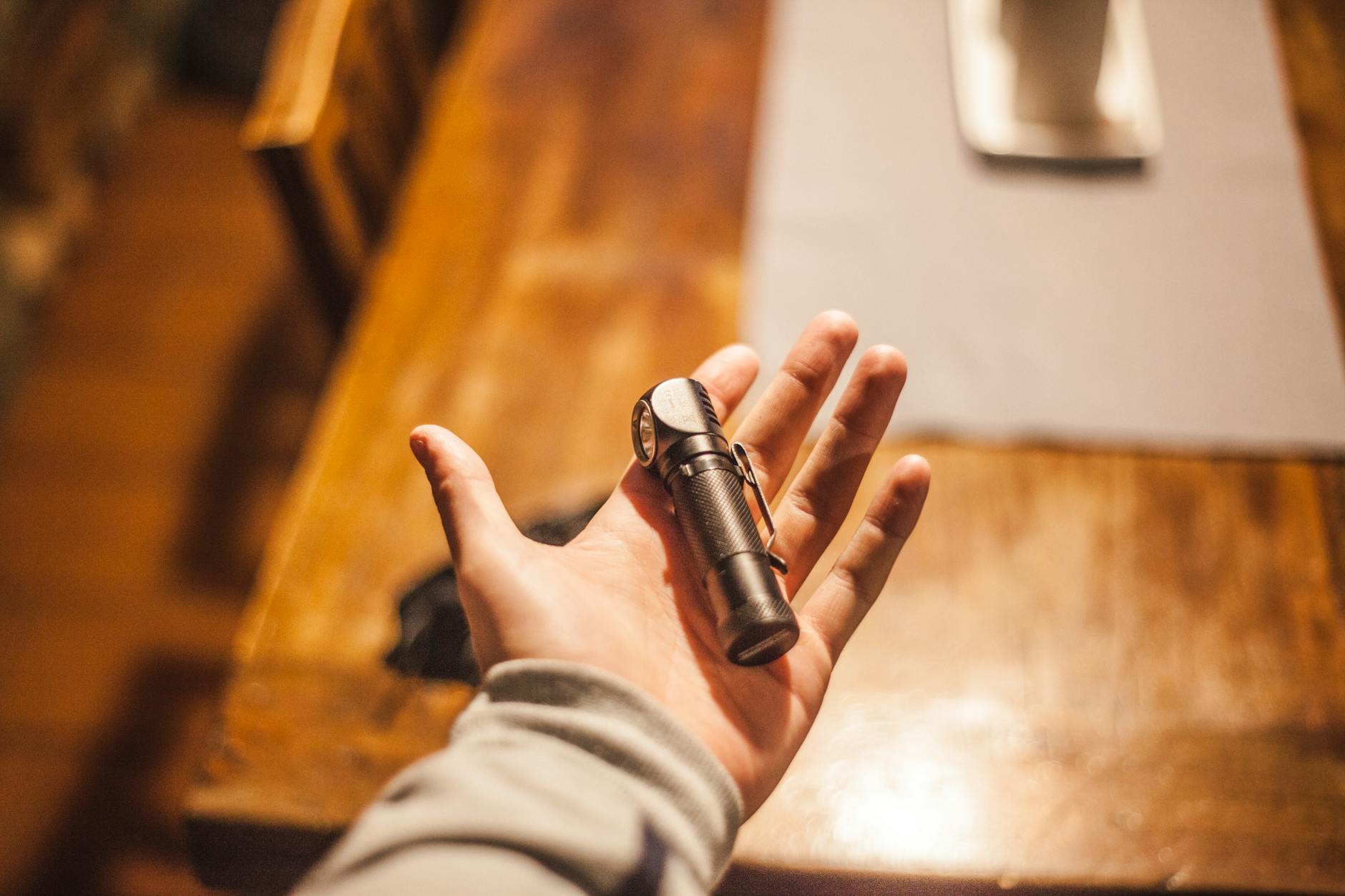 person left hand holding stainless steel tool