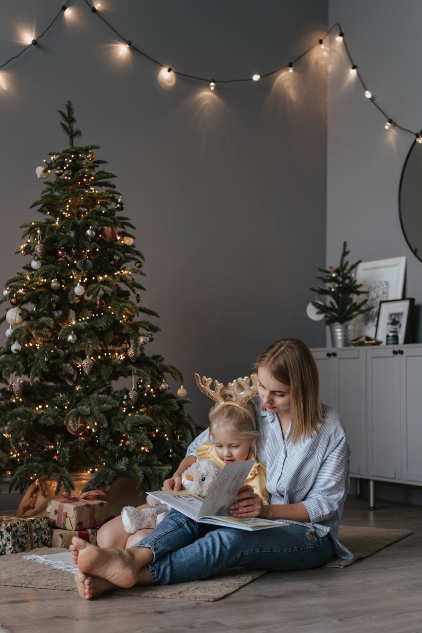 a mother and daughter reading a book on the floor