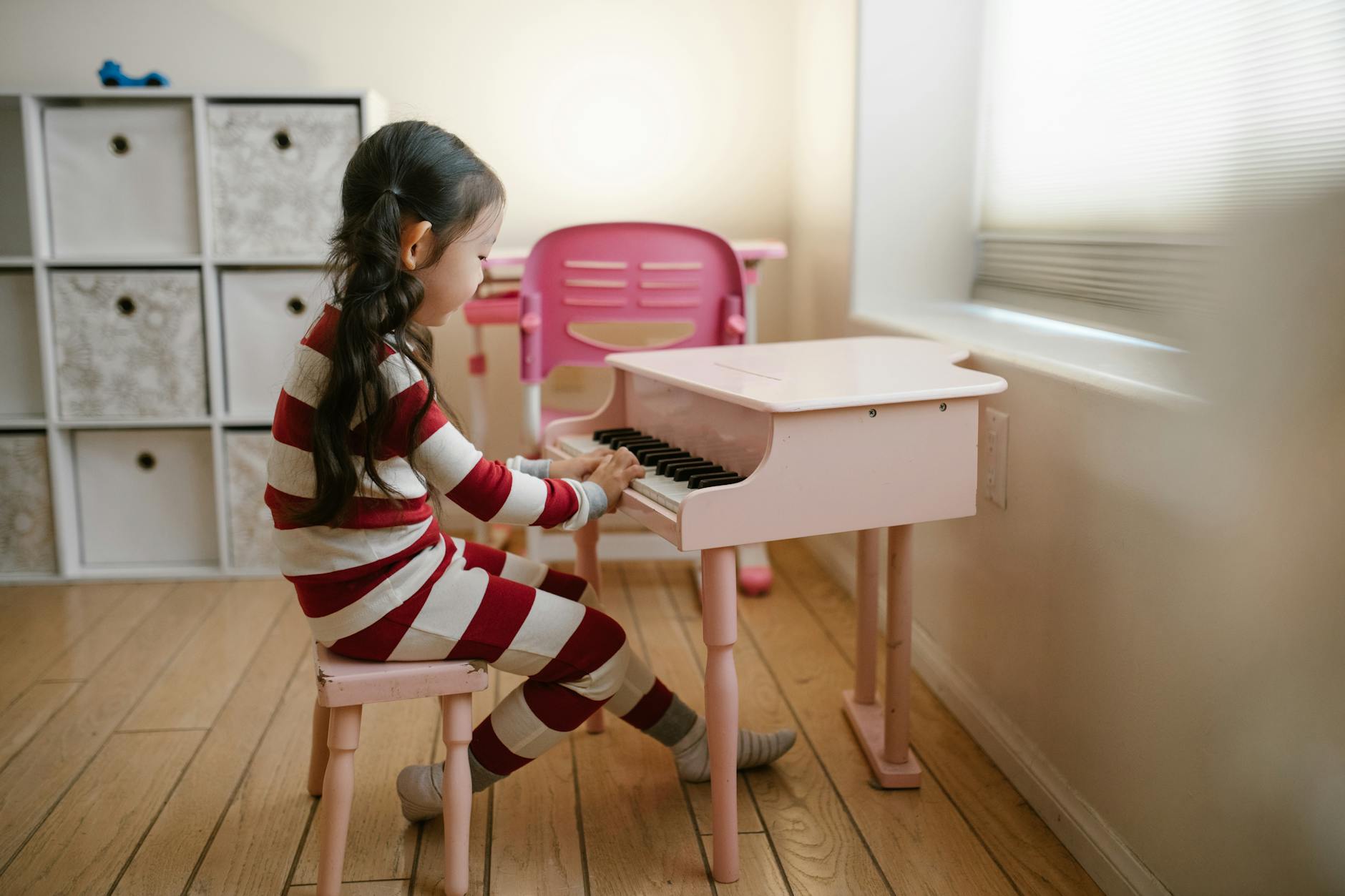 girl playing toy piano at home