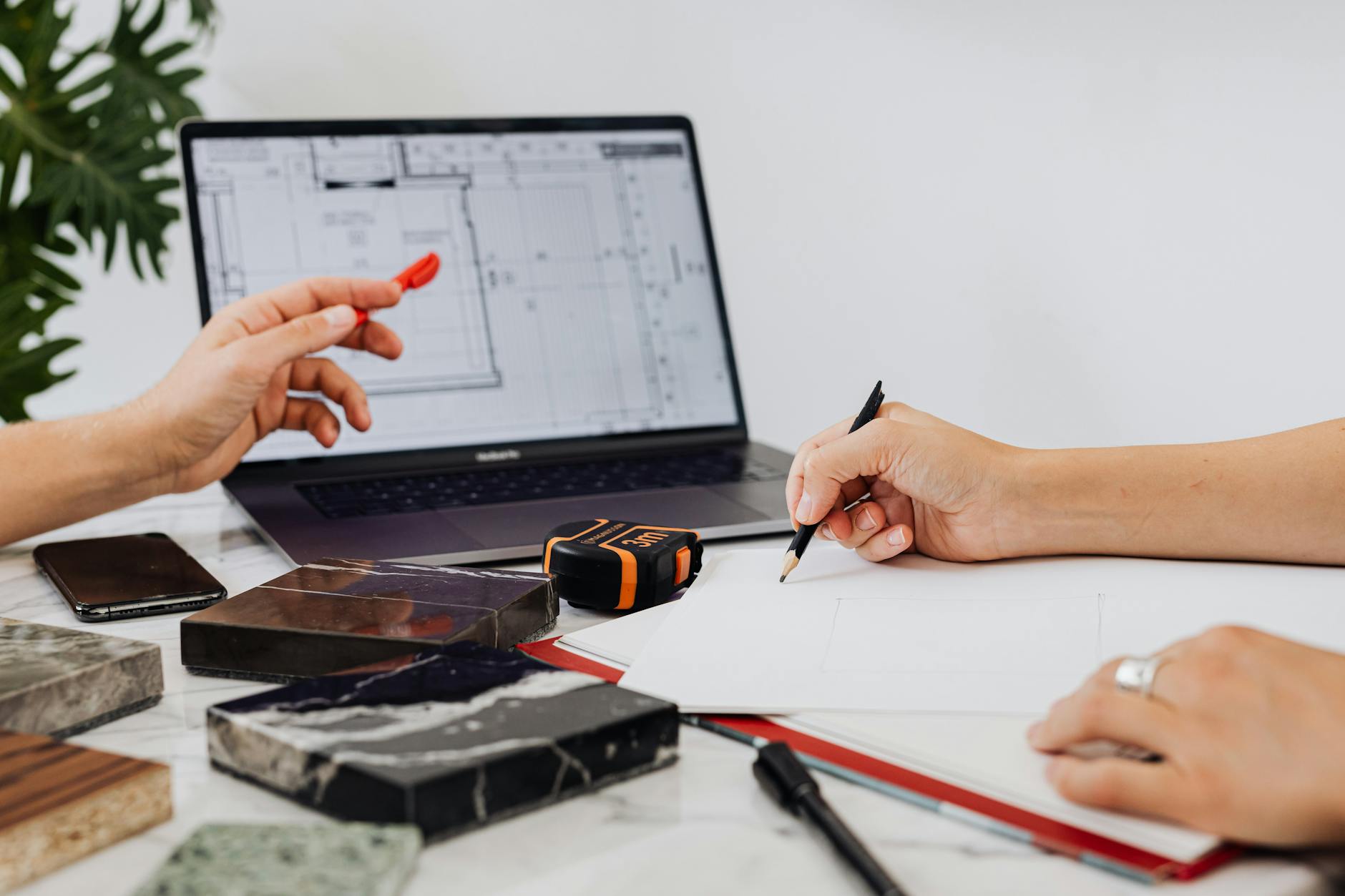 a person using a pencil near tile samples