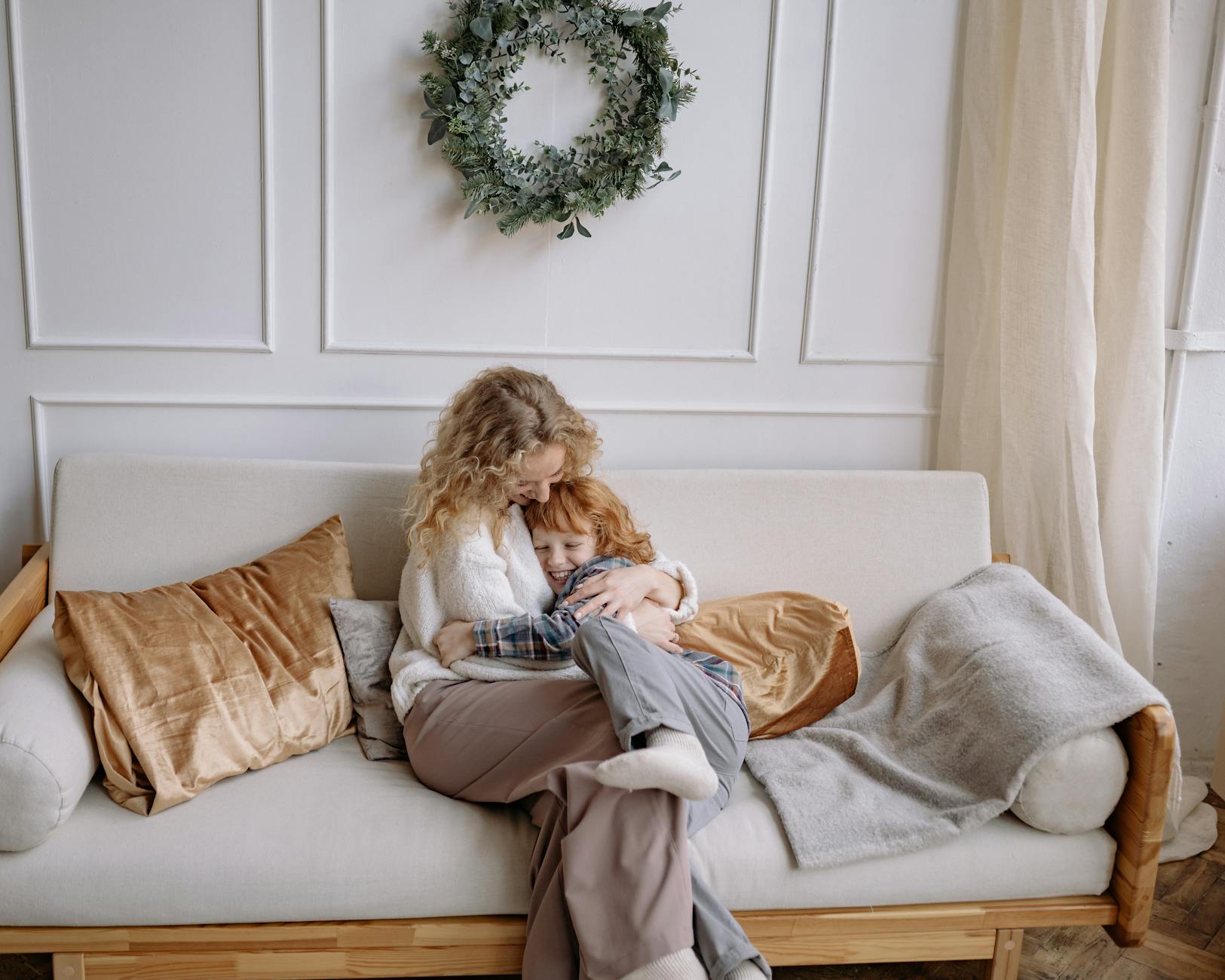 a woman hugging her son on a couch