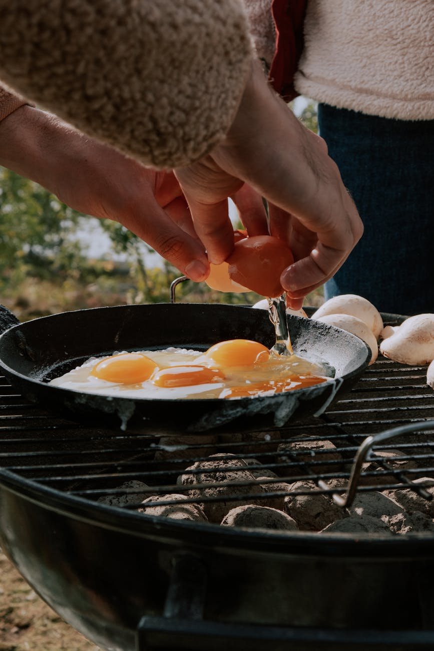 person cooking eggs on a pan