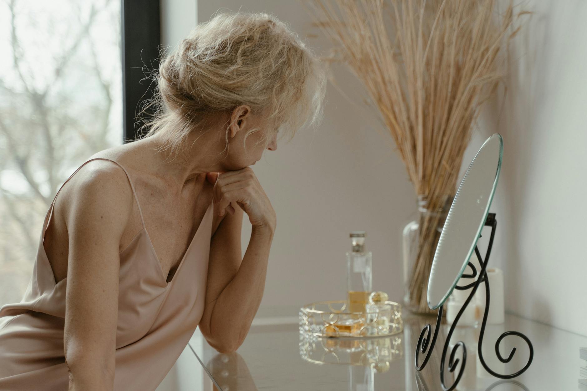 elderly woman sitting in front of a mirror