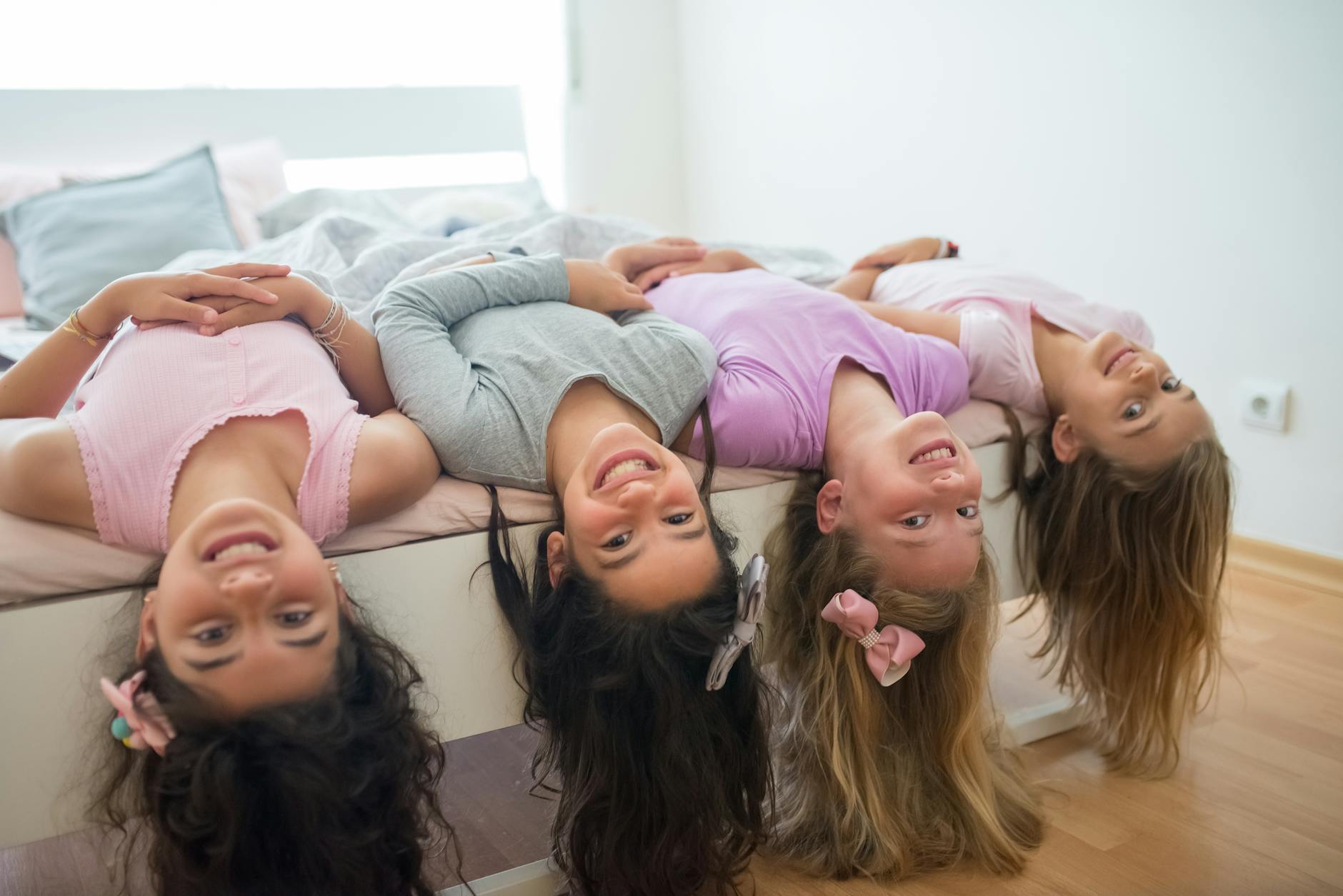 girls lying on bed smiling