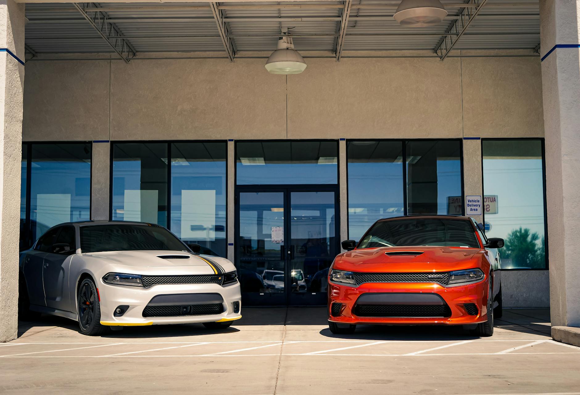 dodge challengers in front of the entrance to the car dealership
