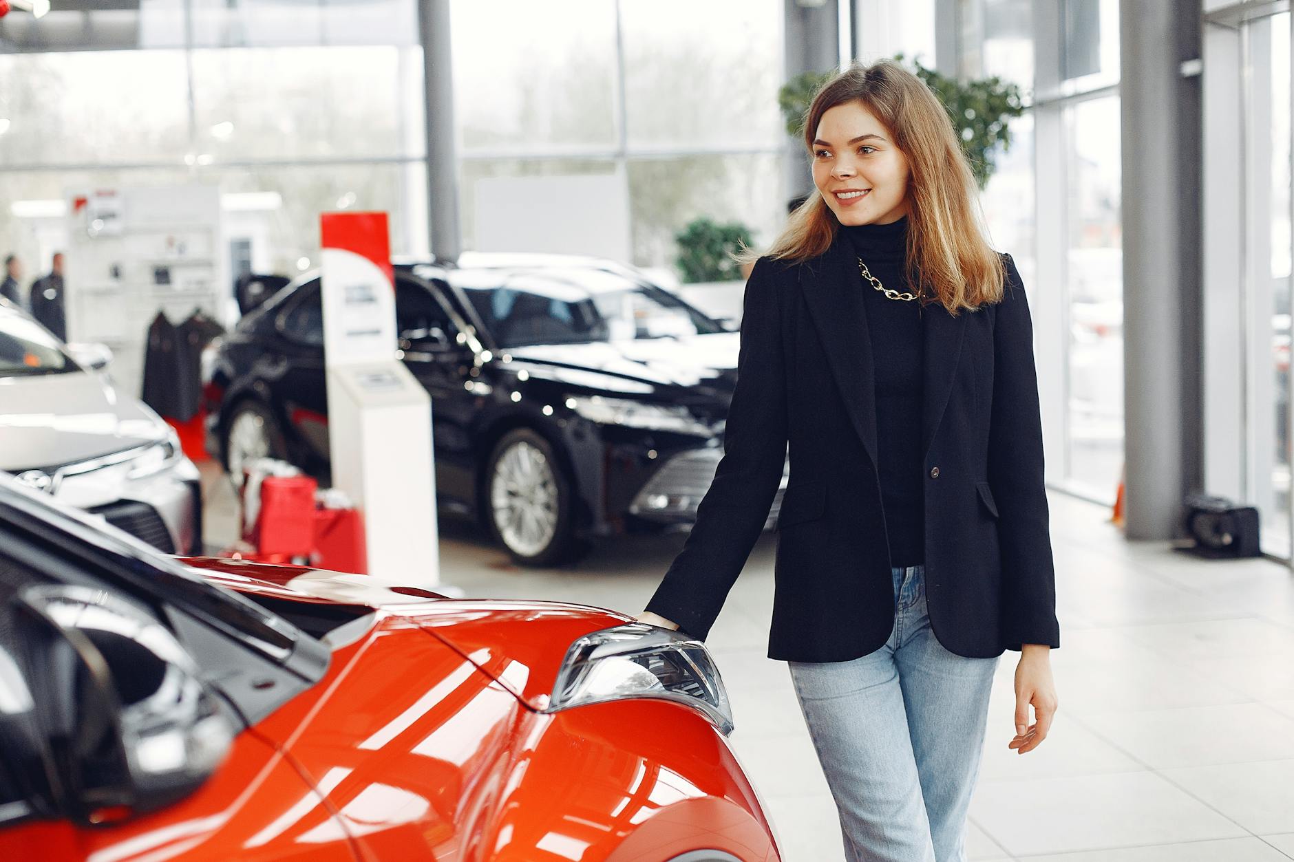 smiling woman looking for a car in a car dealership