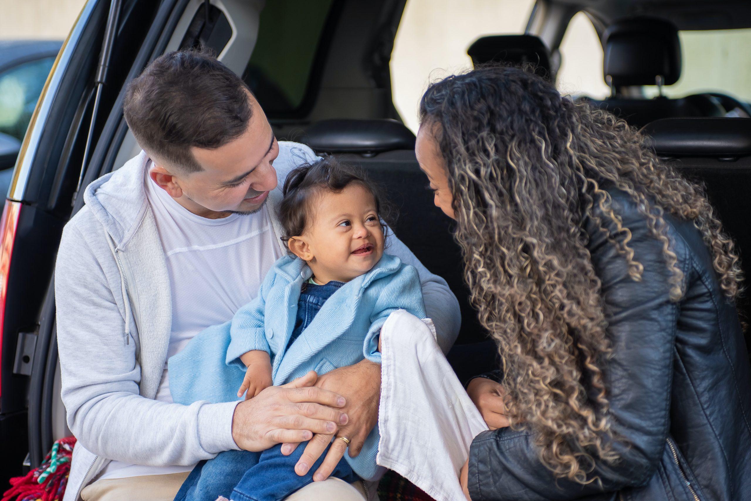 Young family sitting in rear of car