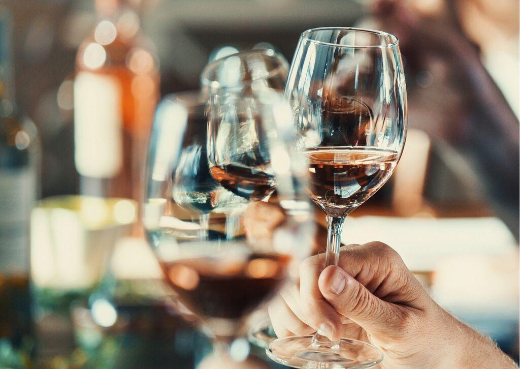 Group of unknown people holding wine glasses during wine tasting.