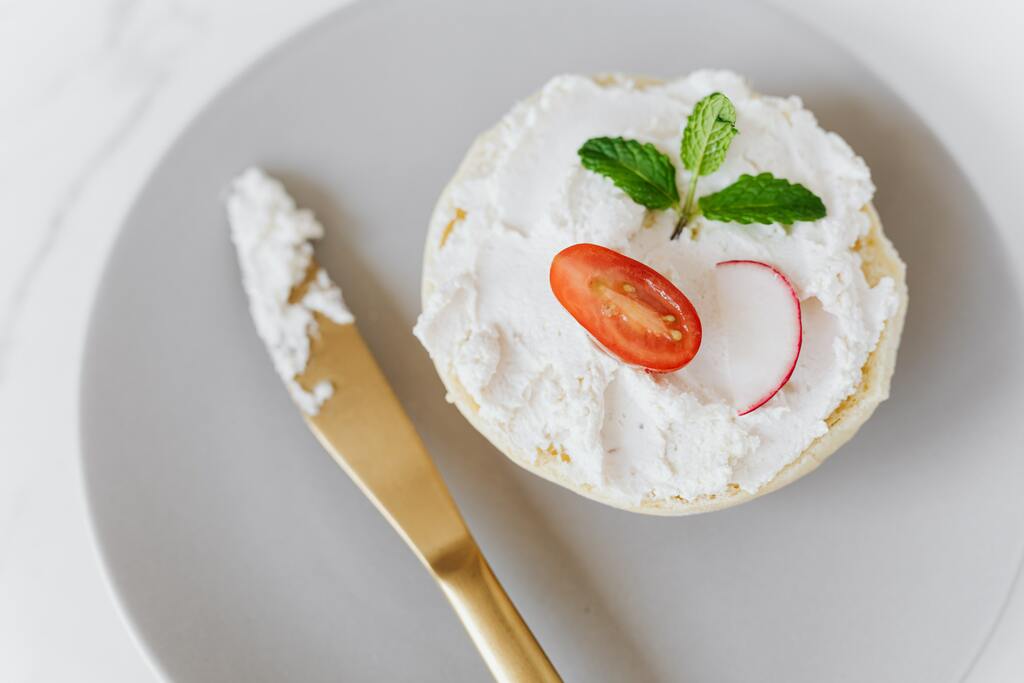 Soft cottage cheese spread on bun with vegetable