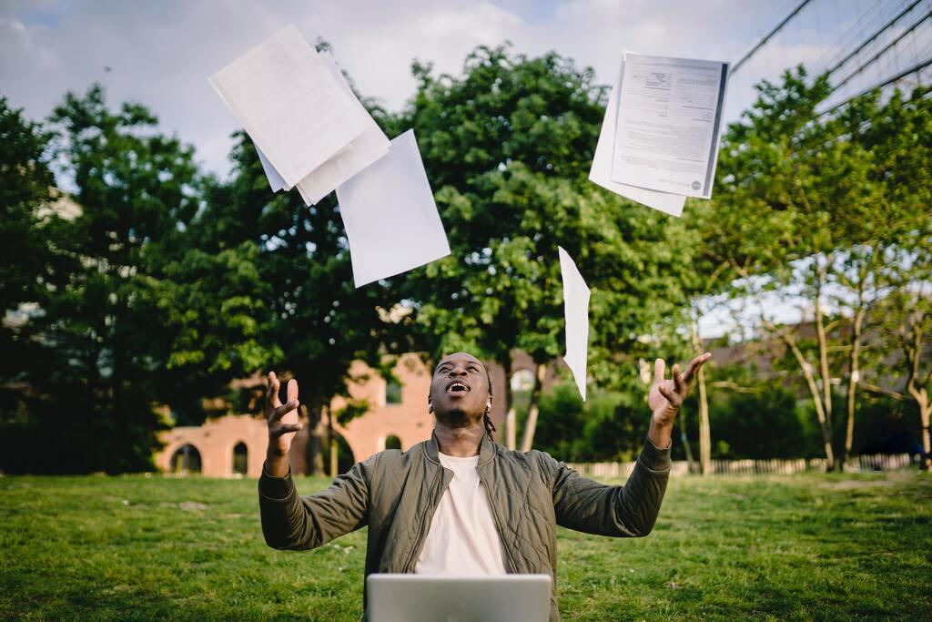 Graduate with papers and laptop excited about getting job