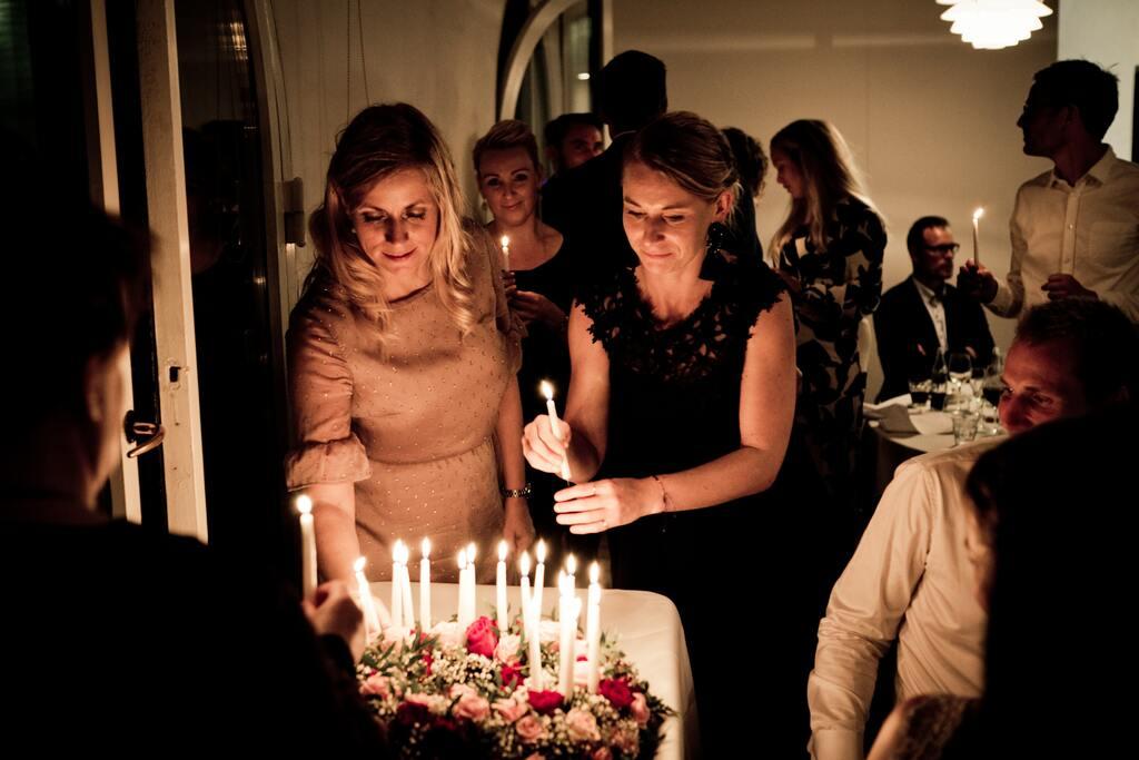 Two Women Holding Candles and lighting a birthday cake