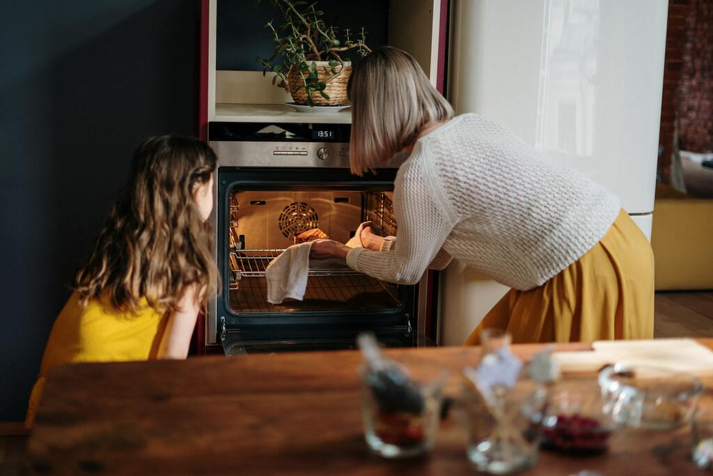A girl helping her mom in the kitchen