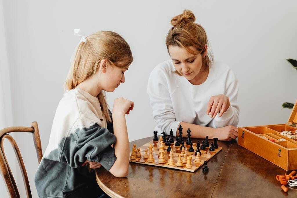 Mother and daughter playing chess.