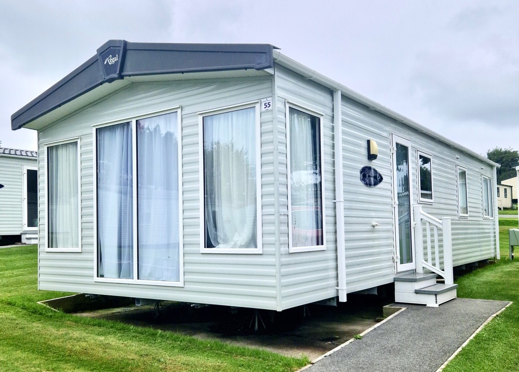 Image of grey static caravan with step and path to the right.