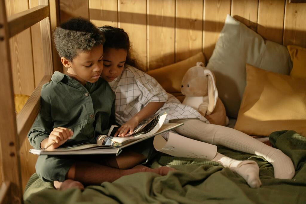 A brother and a sister reading a book together.