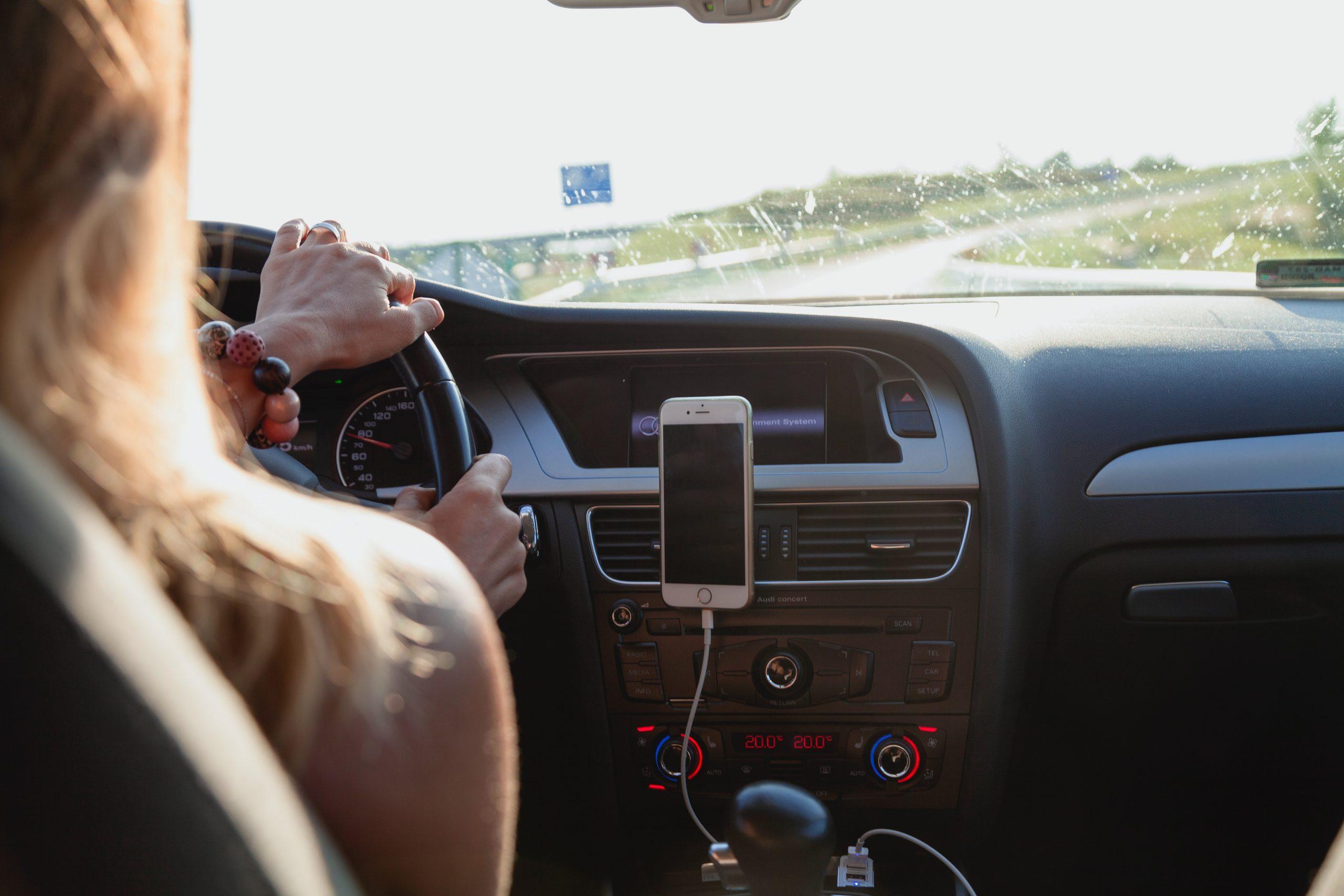 Woman driving on left hand side of car.