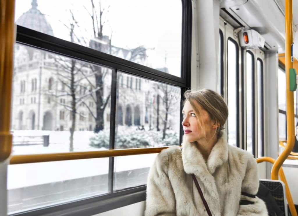 Calm young woman in warm clothes in public transport