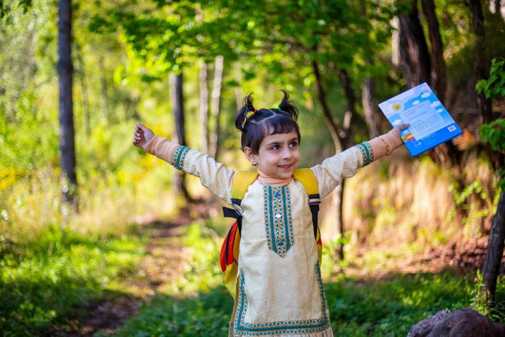Cute Pakistani baby girl reading book, Celebrating, and studying