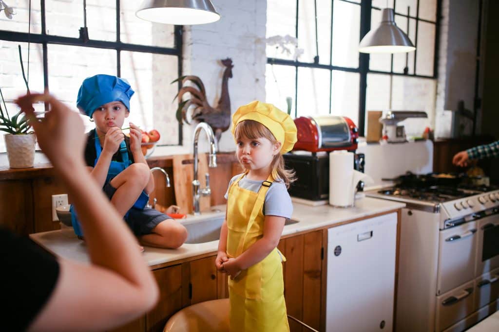 Girl in Yellow Dress Standing Beside Brown Wooden Table