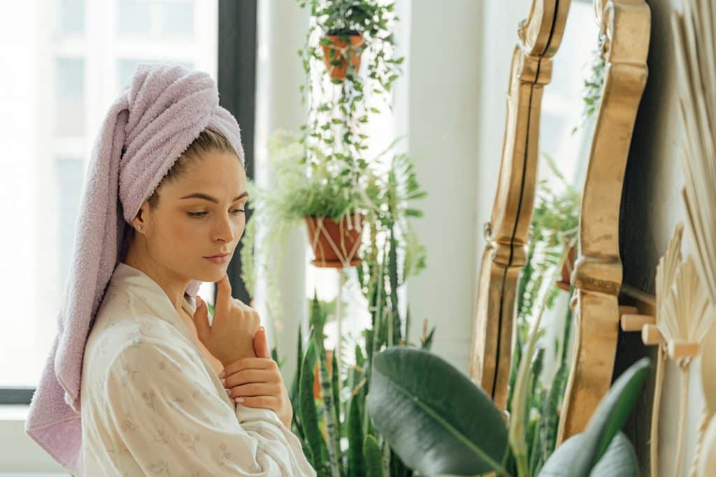 Woman With Head Towel Standing in Front of a Mirror
