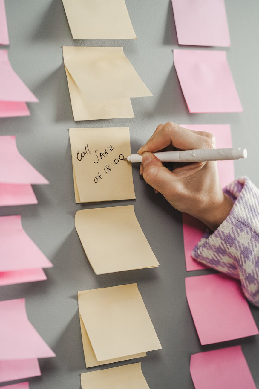 person writing on a sticky note