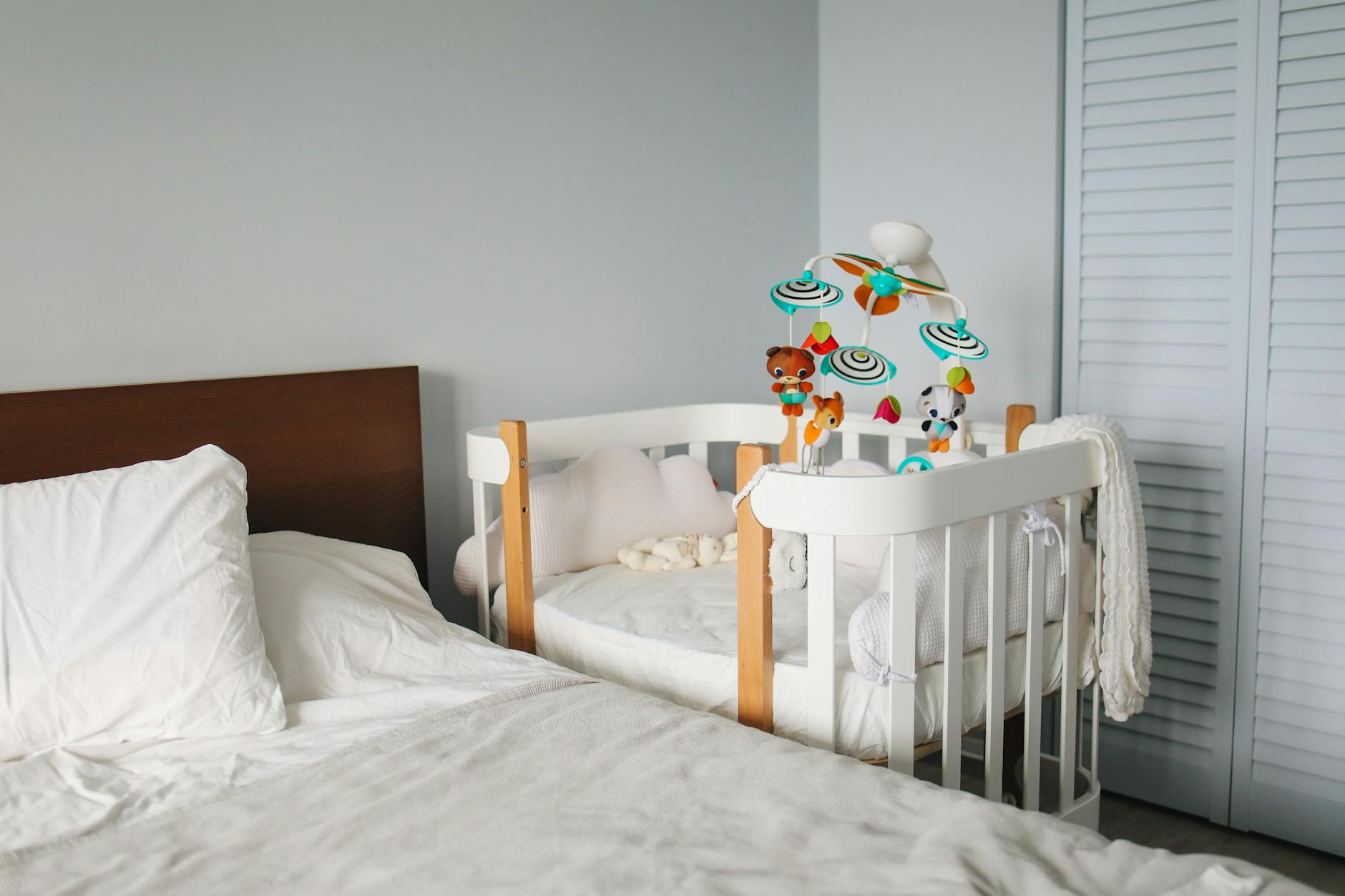 crib next to bed in bedroom