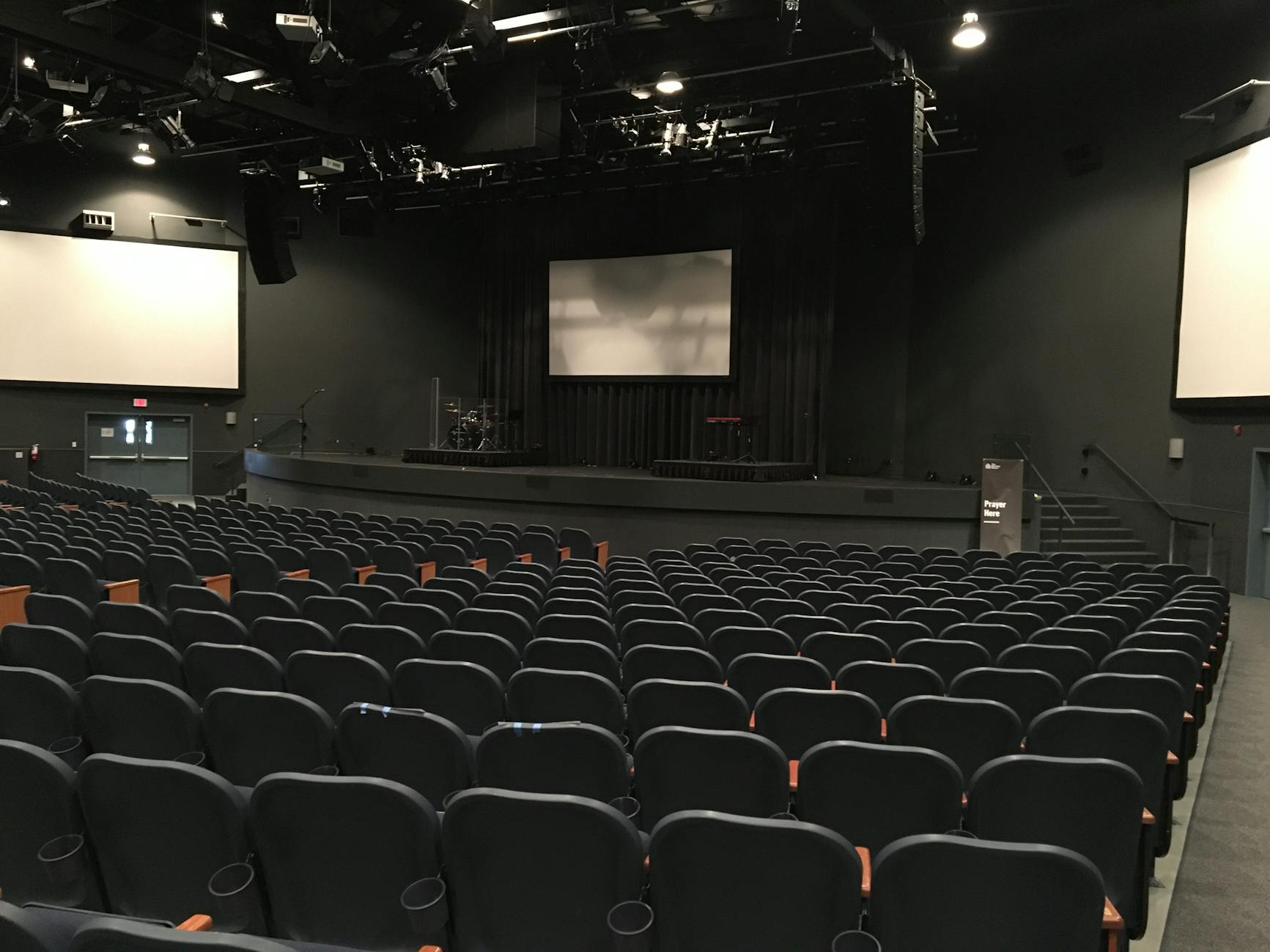 empty cinema theater hall with black chairs and monitors