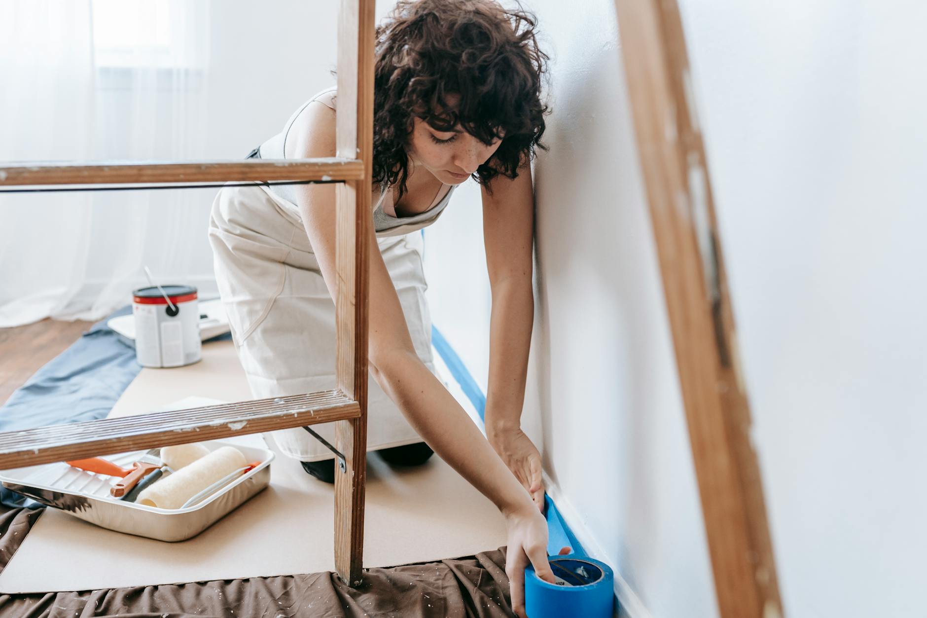 woman putting adhesive tape on wall