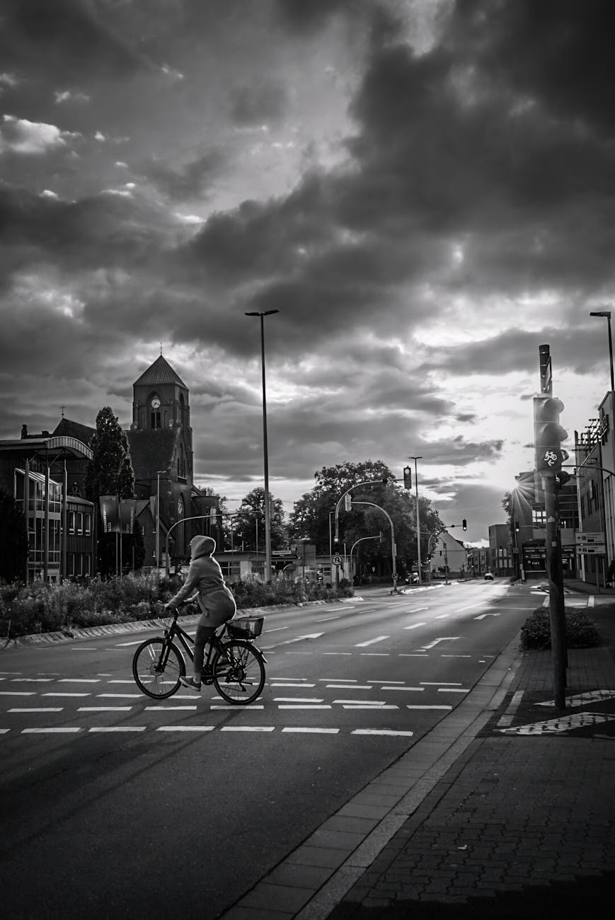 a black and white photo of a person riding a bike