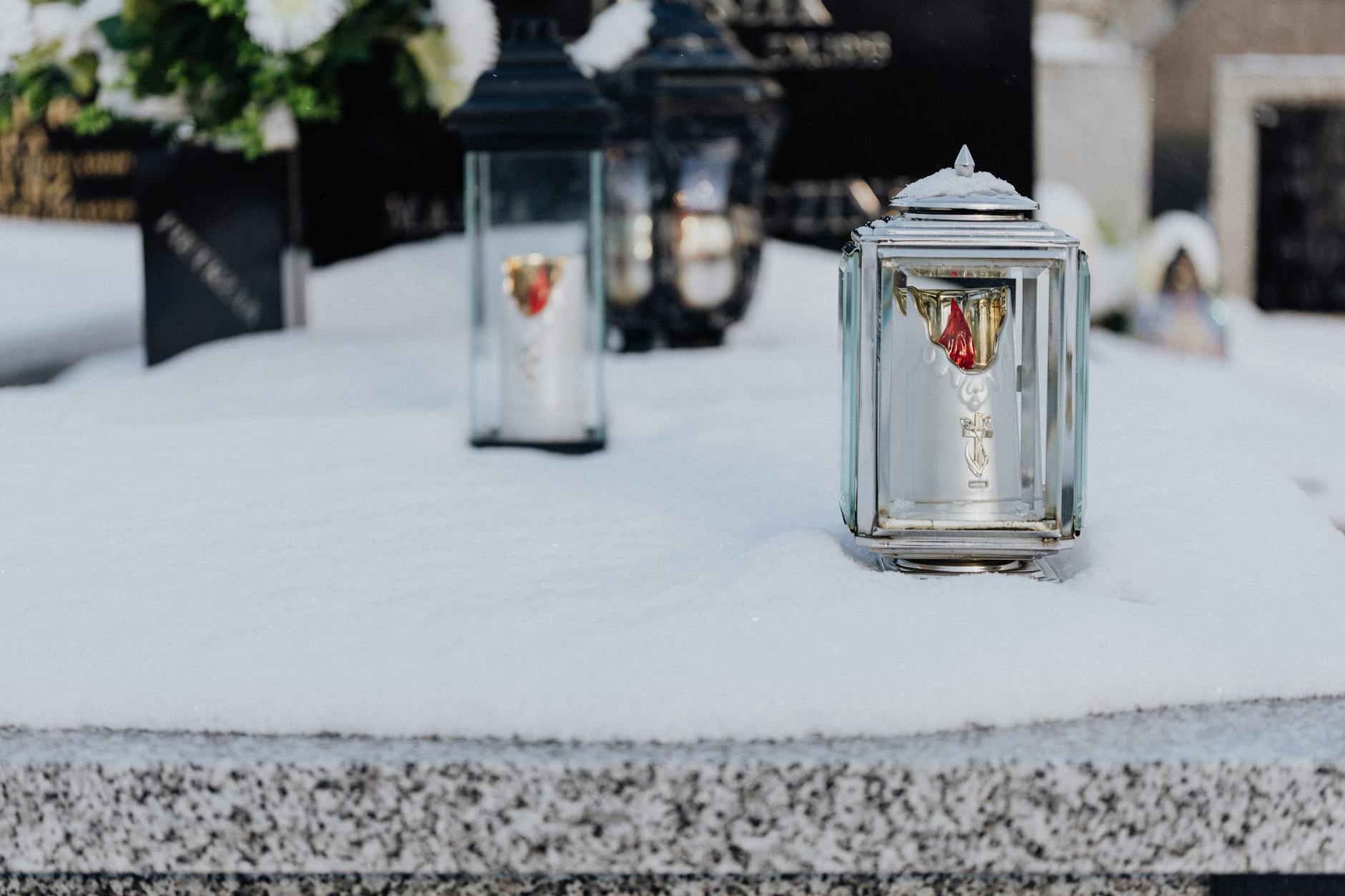 clear glass candle holders on snow covered tomb